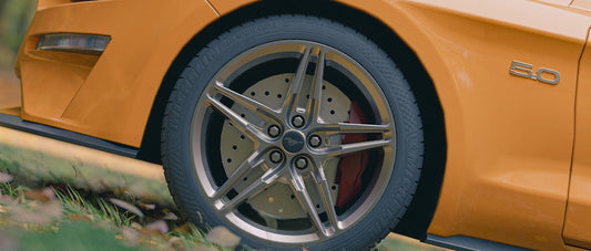 Here is a caption for the image: a yellow sports car's OEM wheel.